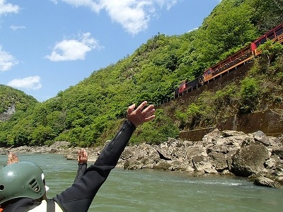 保津川沿いを走るトロッコ列車に手を振る一コマ「ＧＷ、保津川ラフティング盛り上がってます。」