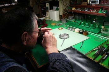 作業台の上には虫眼鏡やピンセットなど様々な道具が整然と並んでいます。