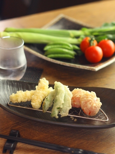 ▲ 新鮮な野菜に衣をまとい、サクサクに揚げた天ぷらはホクホクのうちに。<br>左からヤングコーン、エンドウ、トマト。日本酒との相性も◎。