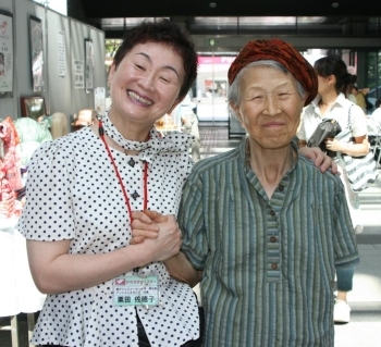手作りの帽子をかぶり笑顔の講習会の常連さん（右）と栗田さん