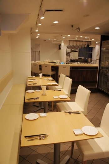 白を基調とした店内は、オープンキッチンのカウンターとテーブル席がございます。