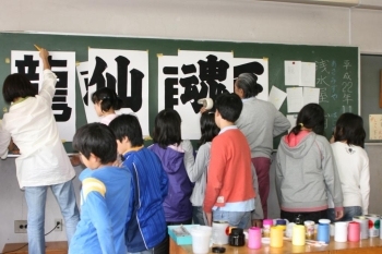 浅水屋さんの後ろに並んで塗料が乾くのを待つ生徒たち。