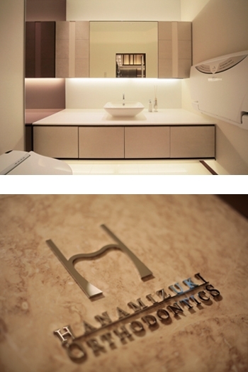 （上）トイレ（下）ロゴ「花みずき矯正歯科」