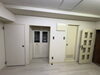 「壁紙と床をダークトーンに一新。24時間レンタルジムの落ち着いた内装リフォーム事例」