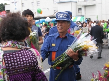 花を配る吉田さん。