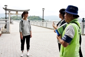 河村会長（右）の説明を受ける丸山さん（左）<br>＝蒲郡市の竹島で