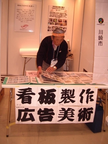 浅水屋さんの仕事の資料が置かれたテーブル前に張られた、看（楷書）板（相撲文字）、製（隷書）作（行書）、広（角ゴシック）告（寄席文字）、美（明朝）術（江戸文字）の文字の一覧表。