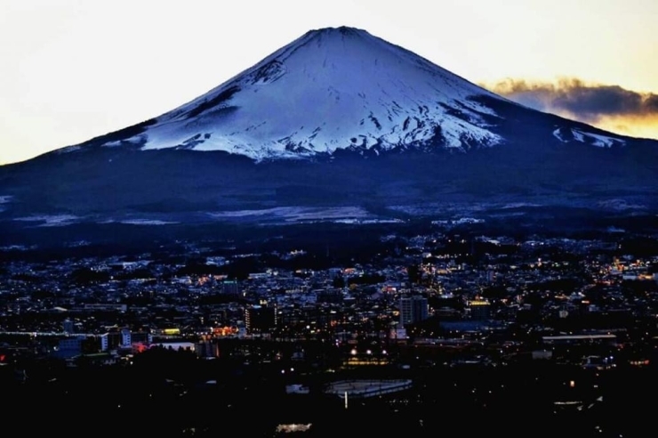 きれいに雪化粧した富士山と、その麓に広がっている、灯りが灯りだした御殿場の街並みを納めました。<br>【カツオ さんからの投稿】