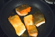 【5】フライパンにオリーブオイルを熱し、鮭の皮面を下にして並べ、弱めの中火で焼く。<br>いい焼き色が付き、上の方まで白っぽく火が通ったら、裏返して、弱火でじっくり中まで焼く<br>お皿に添え野菜を敷き（添えてもいい）、鮭を置いて、ディップをのせる。