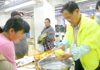 作ったキャベツを見せる田中さん