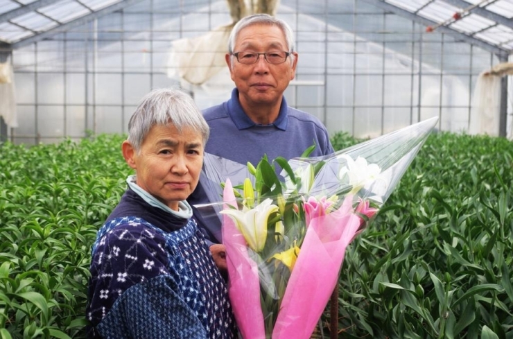 大切に育てた百合の花束を手に、西川慶一さんと奥様。