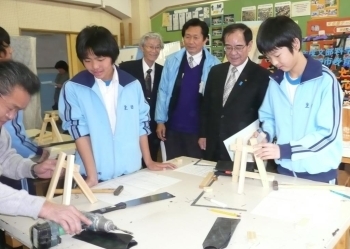 生田中学校で生徒たちの写真立て作りをみつめる阿部市長（右2人目）と若月会長（右4人目）