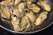 牡蠣は汚れが気になる場合は、塩水でさっと洗い、水気をペーパータオルでしっかりとふきとる。塩ひとつまみをもみこむ。<br>フライパンを熱し、牡蠣を中火で乾煎りする。