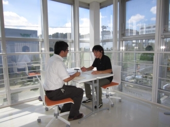 ガラス張りのコーナーで打ち合わせをする橋本<br>さん（左）と持田さん。若手も重要な仕事を任<br>されています。