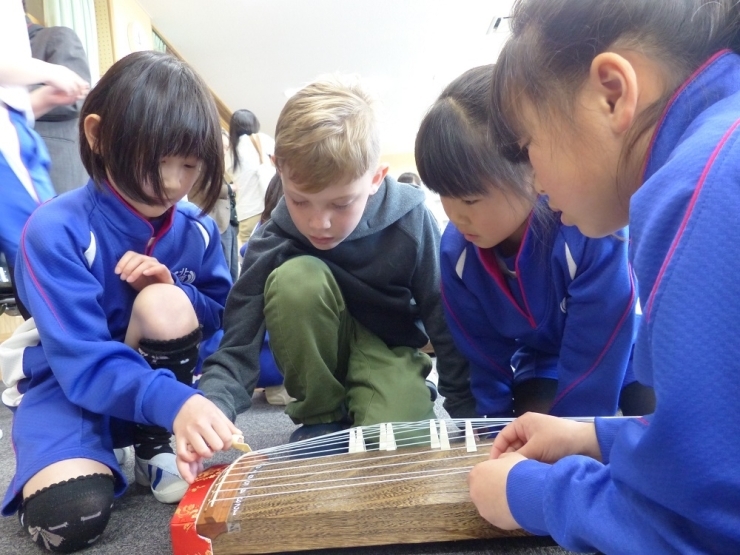 北浦小学校の4年生も演奏するのは今日が初めてだそうです。　音符には弦の番号が書いてありそれを見ながらの演奏でした。マック君も興味深々！