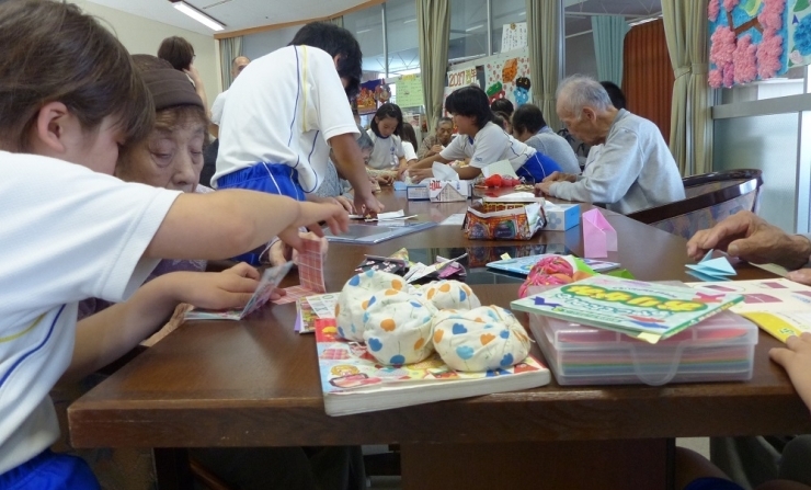 折り紙とお手玉を持った4年生が、おじいちゃん、おばあちゃんの所へ移動！　事前授業で池田さんに、「話かけ」を教えてもらっていたので、とっても上手に話しかけられたね！