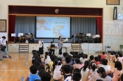プロジェクターを使い、栗田先生らが手順を説明。熱心に耳を傾ける子どもたち