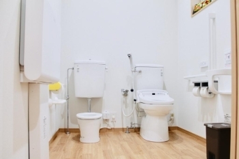 子ども用便器、オストメイト対応トイレ、オムツ替えシート、壁付けベビーチェアのある広いトイレ