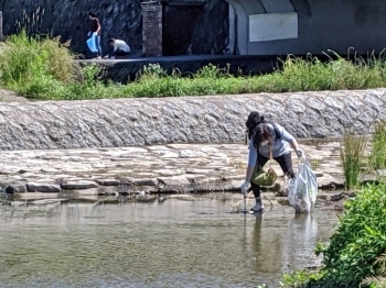 水面に漂うゴミ、もう少しで届きそう