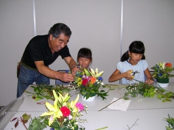 「上手に出来てるね！ここをもうちょっとこうしてみるとお花がしっかり長持ちするよ」…子ども達一人ひとりに笑顔で接する吉田さん。