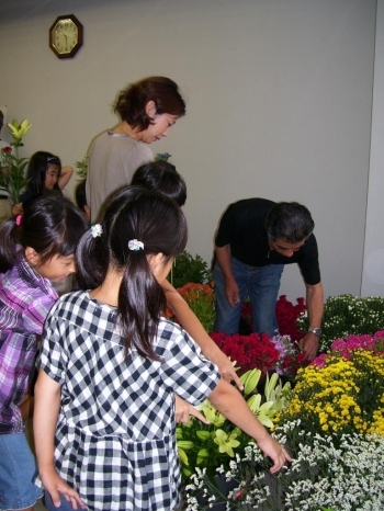 子ども達が選んだお花を手渡す吉田さん。生き生きとしたたくさんのお花に囲まれて子どもも大人も自然と笑顔がほころびます。