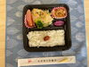 「本日の手作り弁当はバジル香る「白身魚の香草チーズ焼き」！彩り豊かな副菜3品とともに9時30分より販売いたします」
