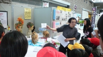 見学にきた小学生達に作品の説明をする三上さん