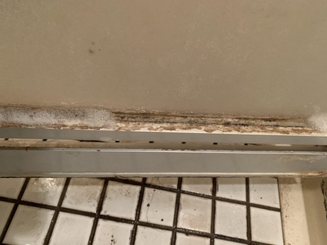 作業前の浴室のドアの下の部分の水アカが目立ちます。「浴室の頑固な水アカの落とし方/浴室清掃はおそうじ革命千葉市川店にお任せください！」