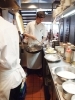 厨房にて料理をする飯田さん