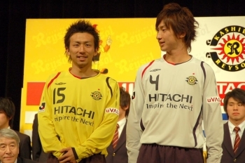 左：ファースト・ユニフォームを着る菅沼実選手（MF・背番号15）<br>右：セカンド・ユニフォームを着る石川直樹選手（DF・背番号4）