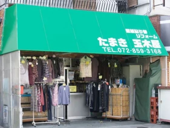 「クロス工事 洋服販売 リビングショップ たまき」テント看板の緑が目印。クロスの張替えご相談ください！！