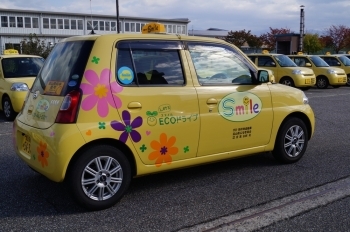 お花とスマイル模様の黄色い車両♪「運転代行Smile」