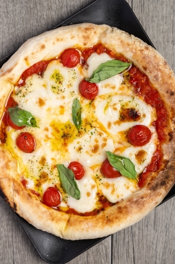 チーズとトマトの酸味が特徴！　当店人気メニューのマルゲリータ。「Yakitori pizza otsu」