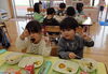 「初めての給食！おいしいね。・・・「がぶっ！！」」