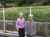 施設玄関の前でヒマワリをバックに撮影「ひまわり畑、一日で黄色が増したような」
